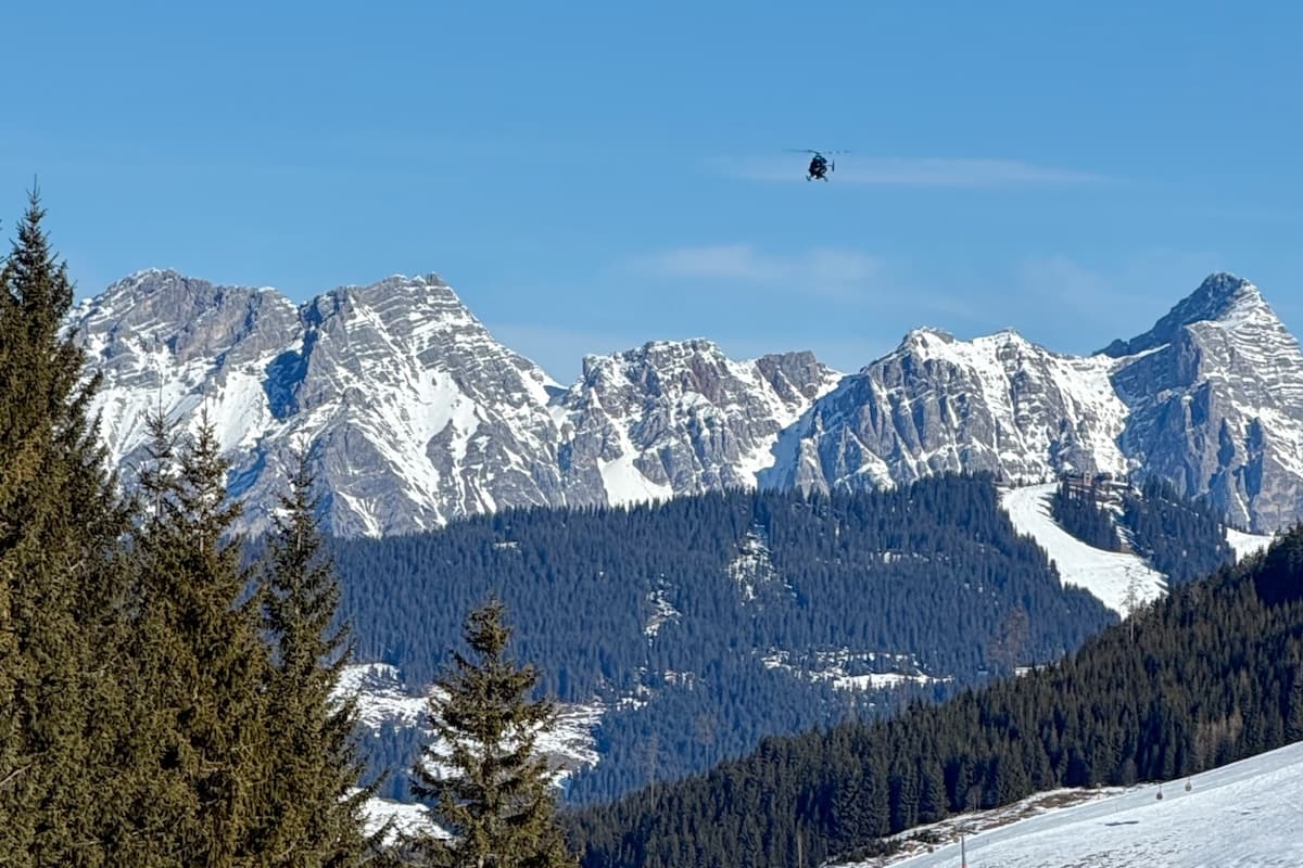 Mountain Rescue helicopter flying above Austrian Alps in the snow