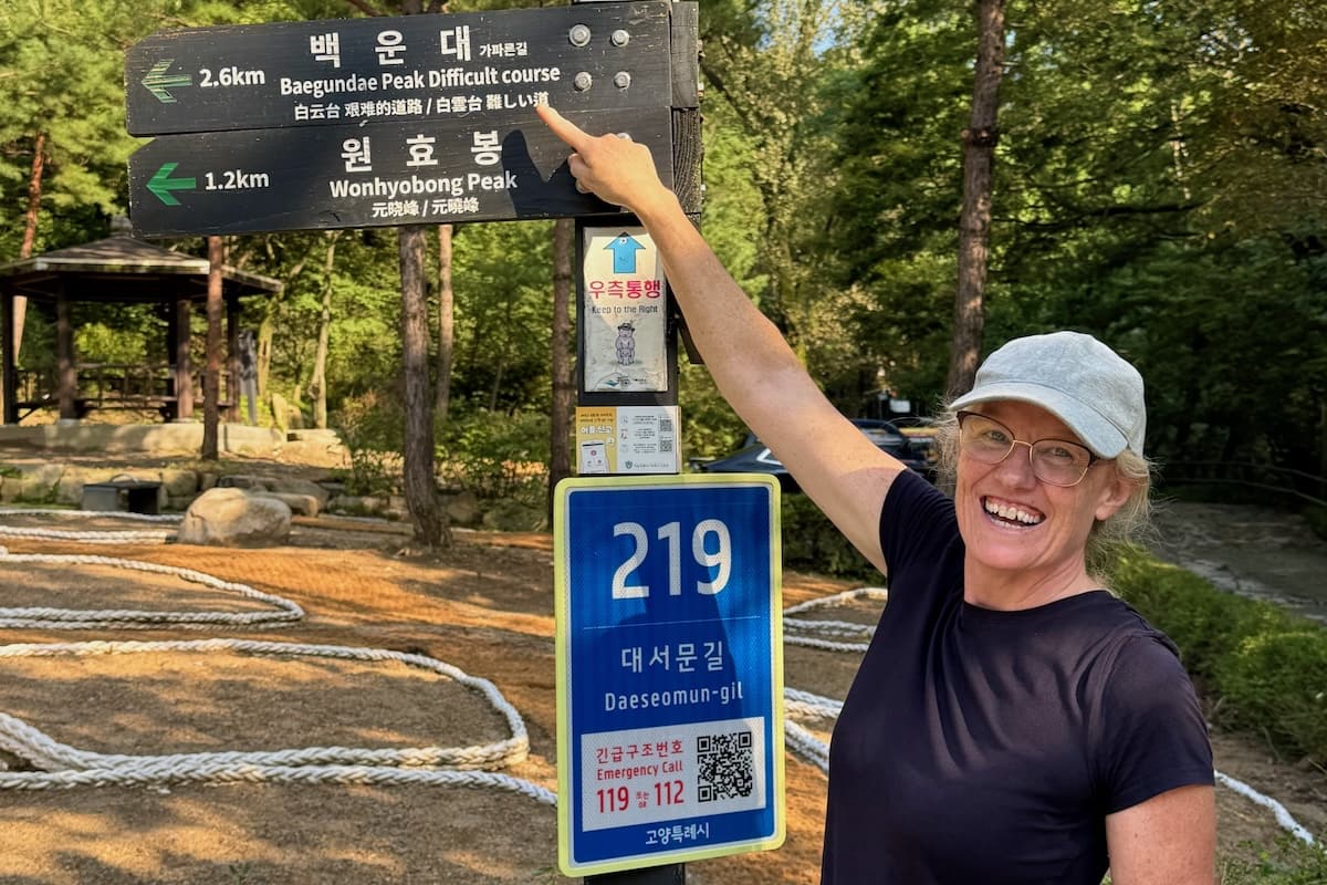 Woman pointing at difficult route sign on Bukhansan hiking trail