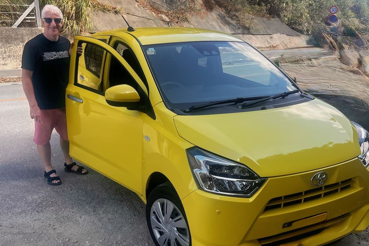 Man looking after yellow Toyota Car