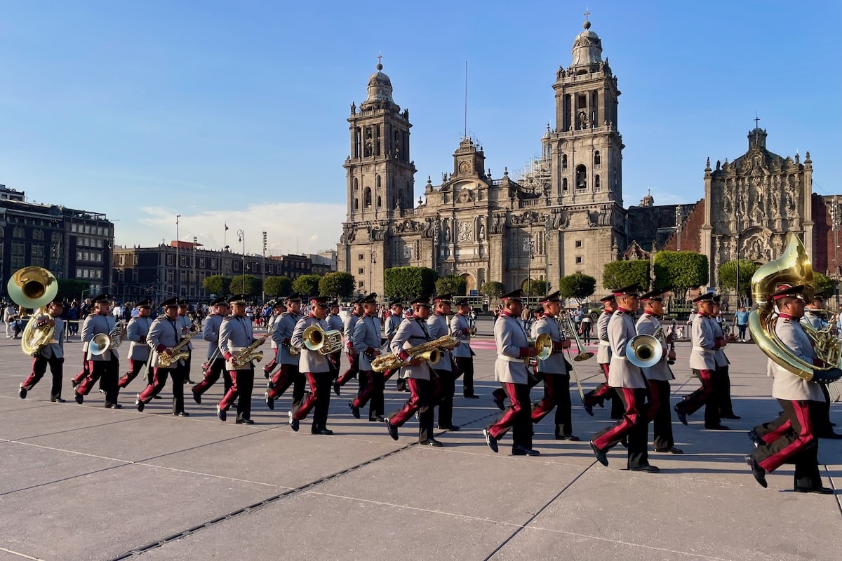Brass band marching past Metropolitan Cathedral in Mexico City