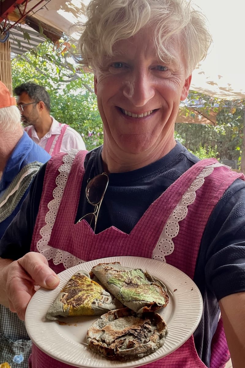 Man proudly holding plate of empanadas at cooking class in Oaxaca, Mexico