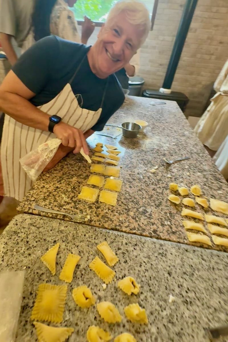 Man smiling at his pasta making in class in Tuscany